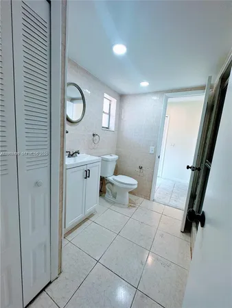 an empty room with white walls and fan