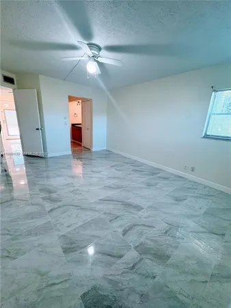 en empty room with windows and fan