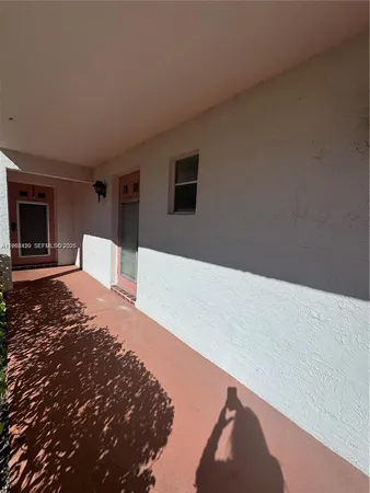 a view of a white house with a big yard and large tree