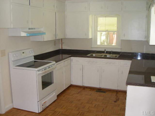 1218 Southerlund Road Garner, NC 27529 - Photo 4 of 10 a kitchen with granite countertop white cabinets and white appliances