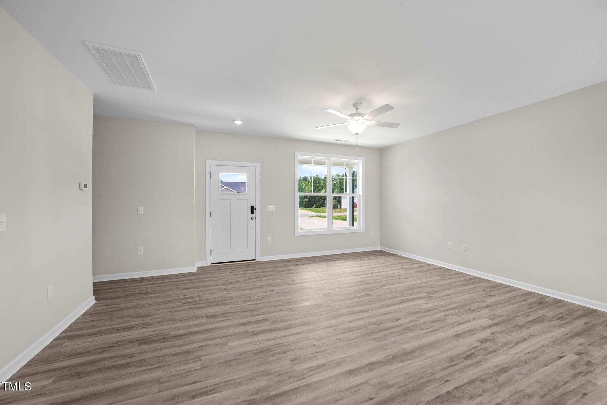 140 Brookhaven Drive Spring Hope, NC 27882 - Photo 11 of 32 a view of an empty room with wooden floor and a window