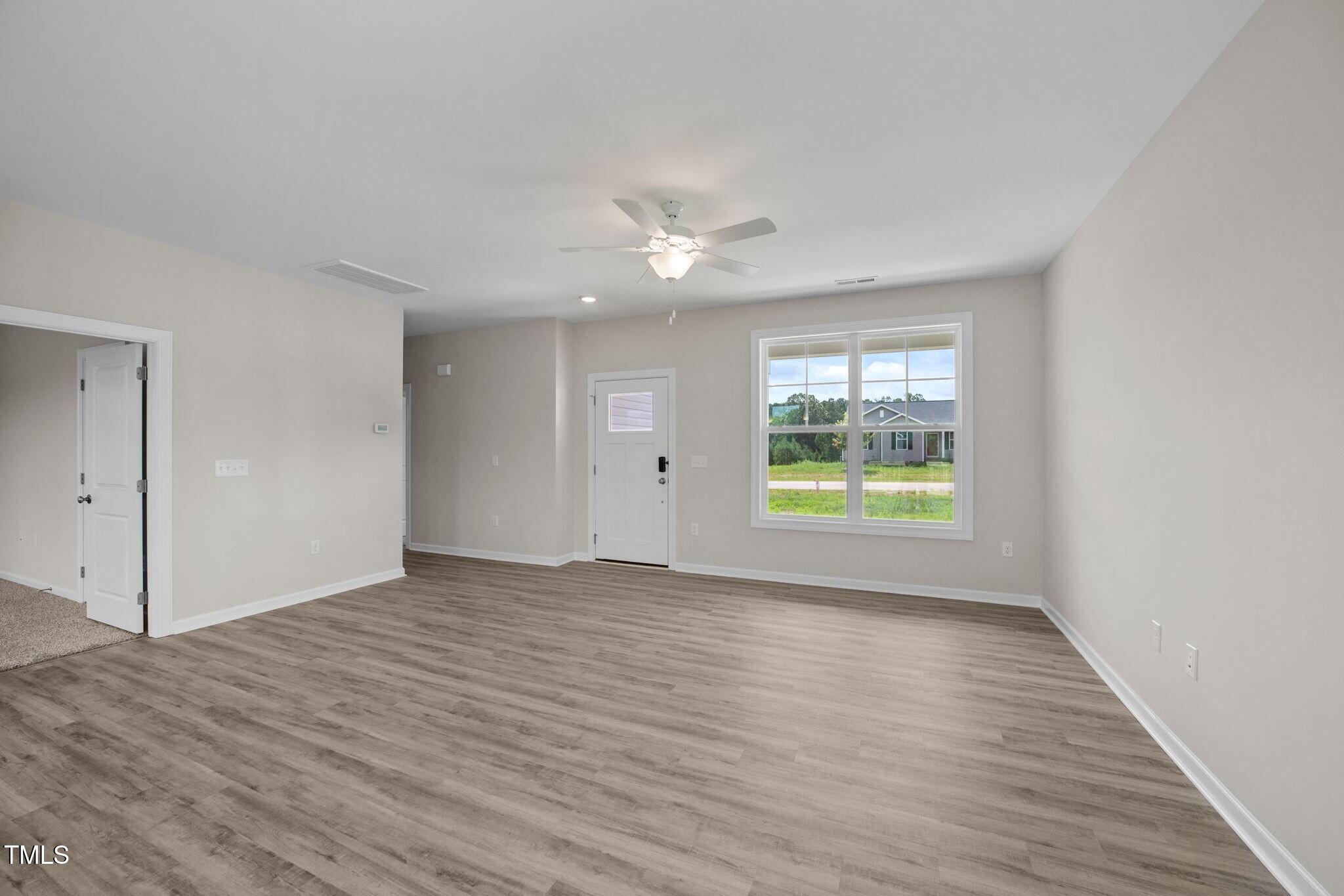 140 Brookhaven Drive Spring Hope, NC 27882 - Photo 12 of 32 a view of an empty room with a window and wooden floor