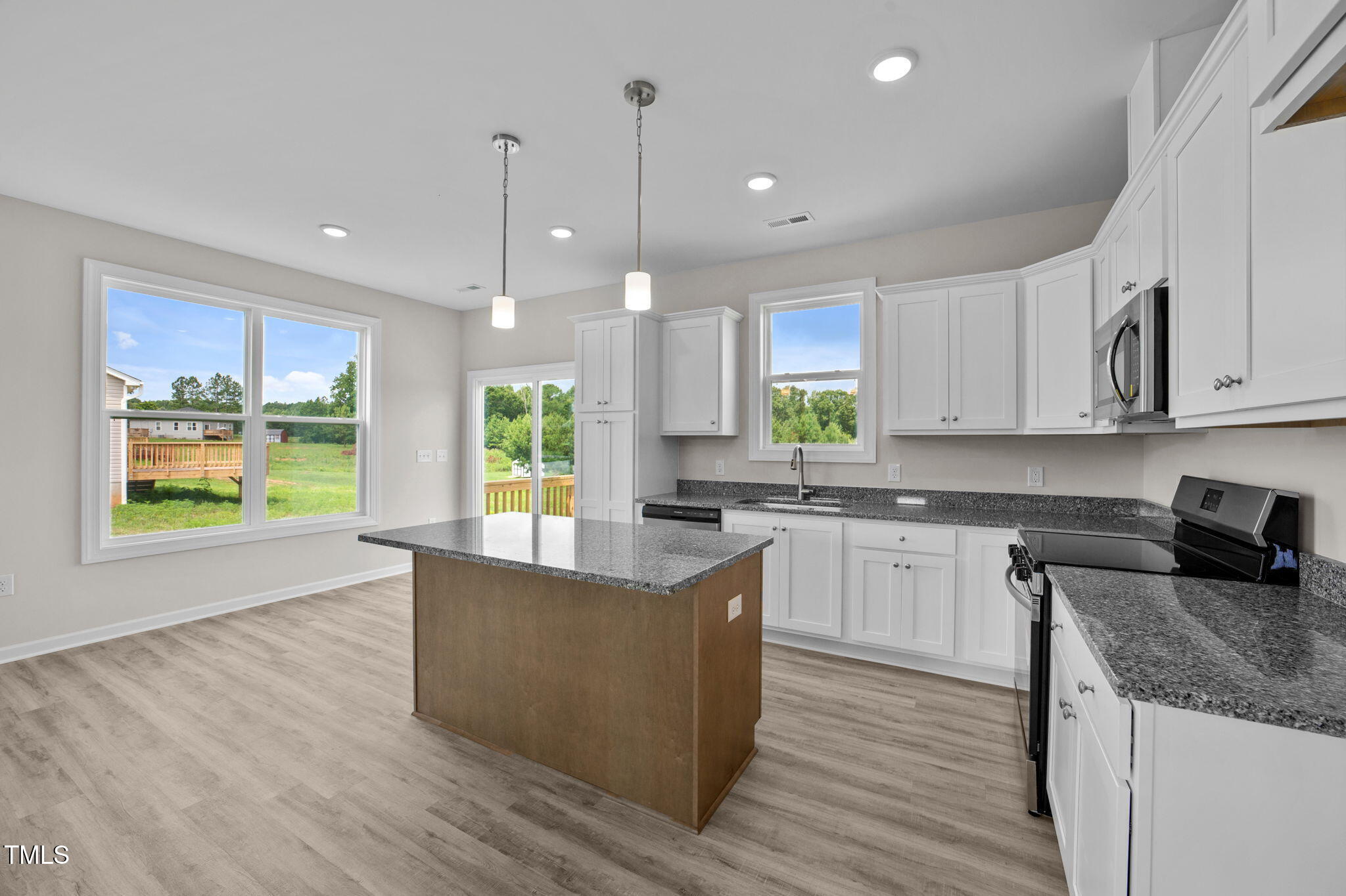 140 Brookhaven Drive Spring Hope, NC 27882 - Photo 8 of 32 a kitchen with stainless steel appliances granite countertop wooden floor sink and window