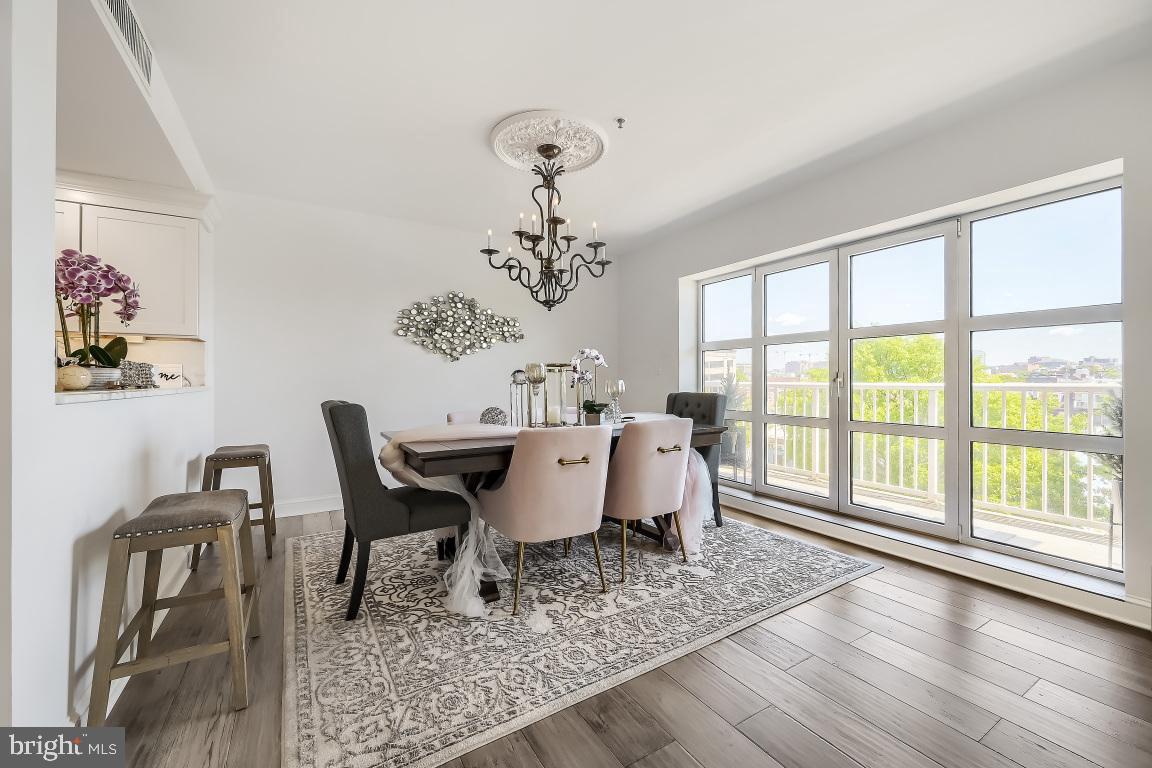250 President Street, Unit 211 Baltimore, MD 21202 - Photo 11 of 63 a dining room with wooden floor and a chandelier