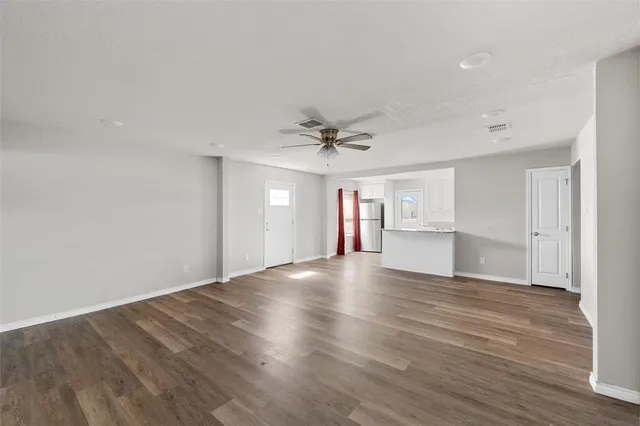a view of an empty room and window and wooden floor