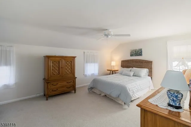 a bedroom with a bed and a lamp on dresser