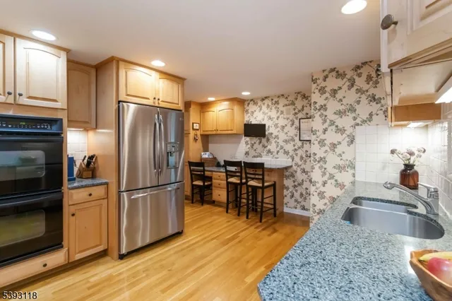 a kitchen with granite countertop a sink appliances and cabinets