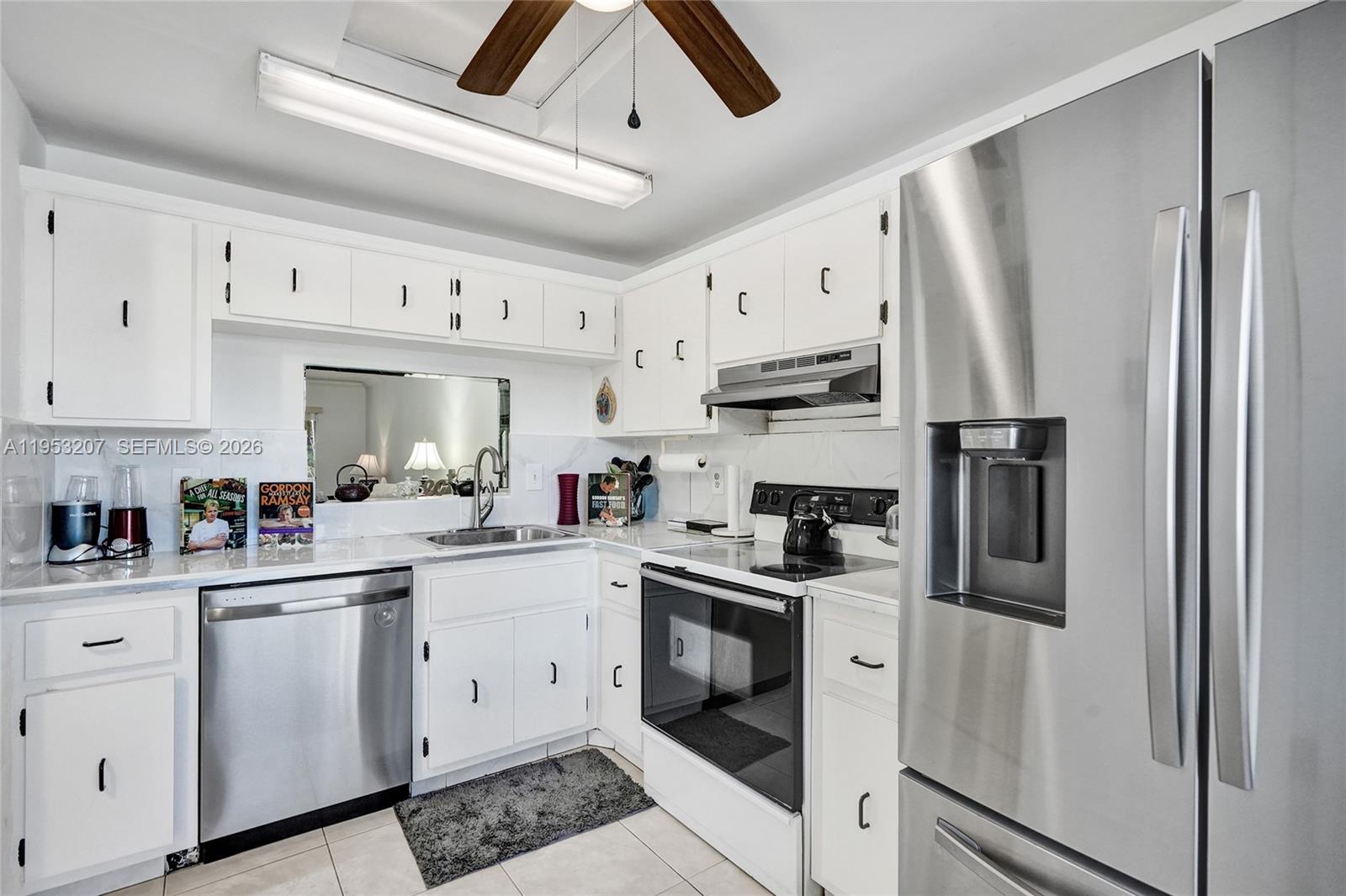 3511 Inverrary Drive, Unit 107 Lauderhill, FL 33319 - Photo 13 of 47 a kitchen with white cabinets and stainless steel appliances