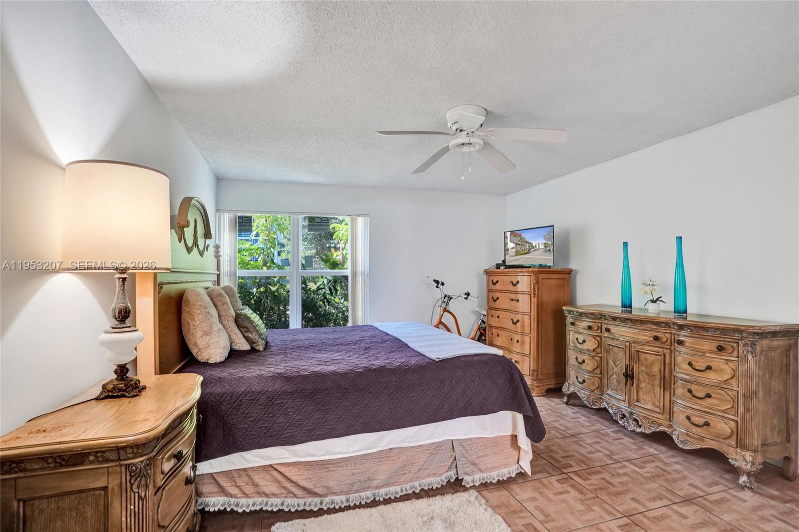 3511 Inverrary Drive, Unit 107 Lauderhill, FL 33319 - Photo 29 of 47 a bedroom with a bed a chandelier and dresser
