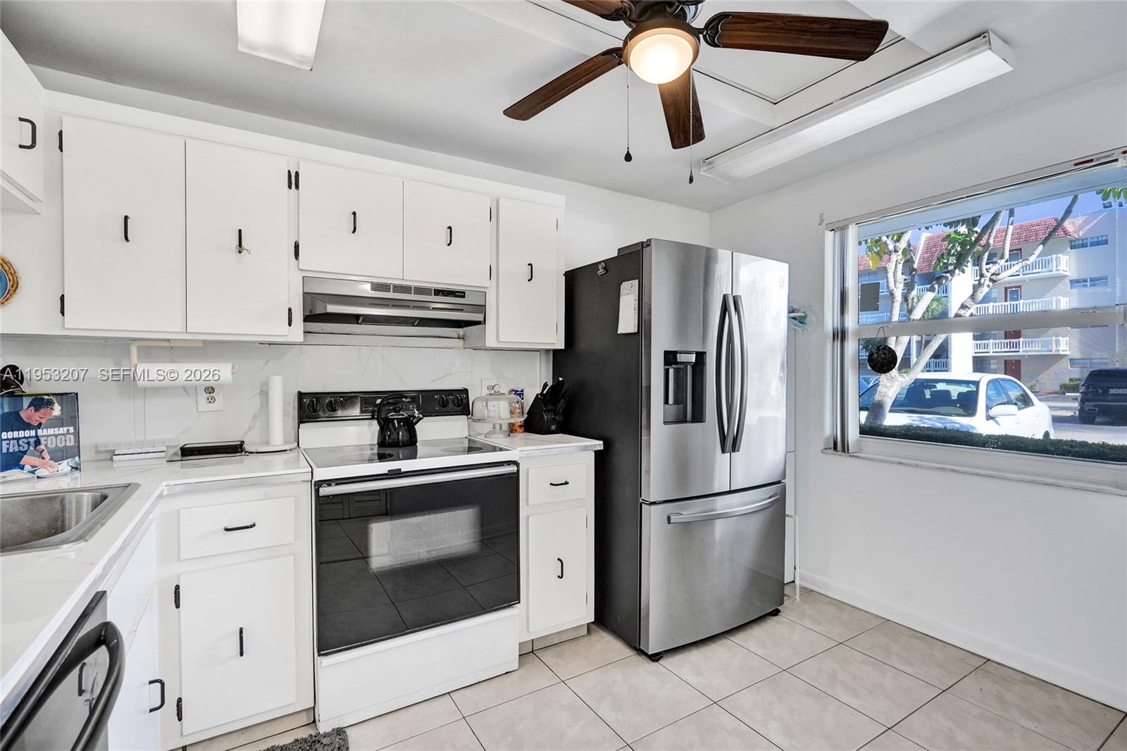 3511 Inverrary Drive, Unit 107 Lauderhill, FL 33319 - Photo 9 of 47 a kitchen with stainless steel appliances granite countertop a refrigerator a stove a sink and dishwasher with wooden floor