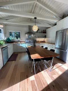 a kitchen with a table chairs refrigerator and cabinets