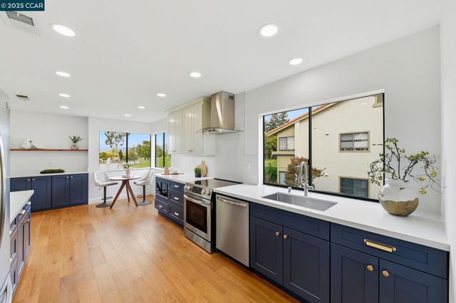 a kitchen with stainless steel appliances granite countertop sink stove dining table and chairs