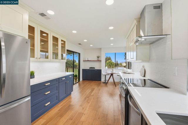 a kitchen with stainless steel appliances granite countertop a refrigerator and a stove top oven