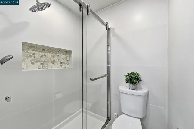 a white toilet sitting next to a bath tub