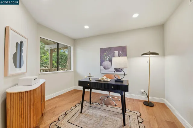 a view of a workspace with furniture and a window