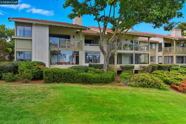 a front view of a house with a yard and potted plants