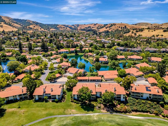 an aerial view of residential houses with outdoor space and ocean view