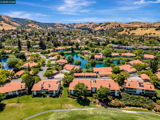 an aerial view of residential houses with outdoor space and ocean view