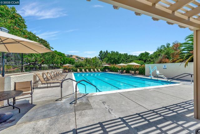 a view of a patio with a table and chairs under an umbrella