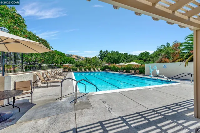 a view of a patio with a table and chairs under an umbrella