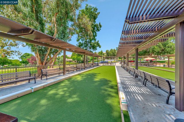 a view of a swimming pool with a patio and a yard