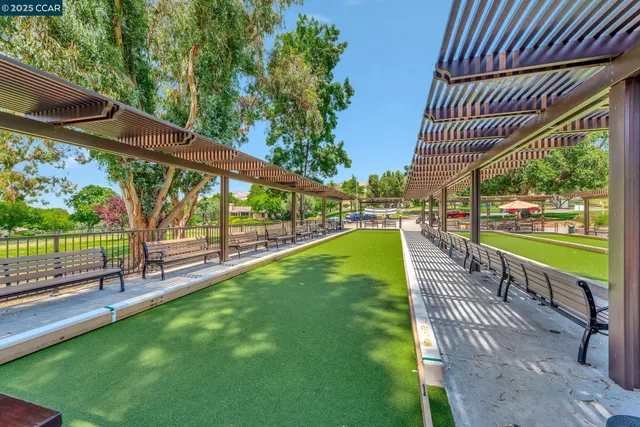 a view of a swimming pool with a patio and a yard