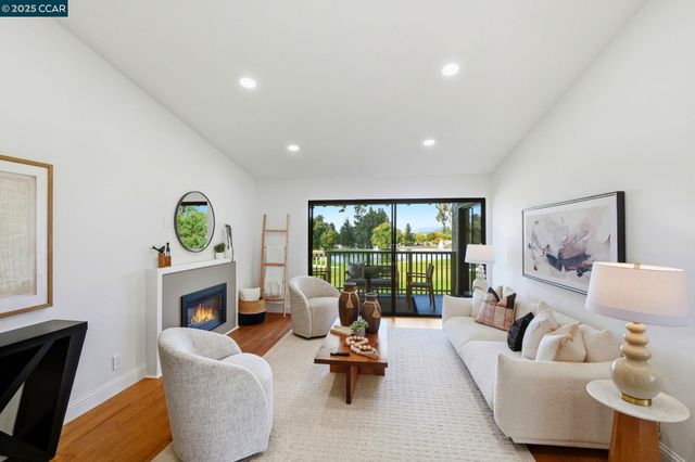 a living room with fireplace furniture and a large window