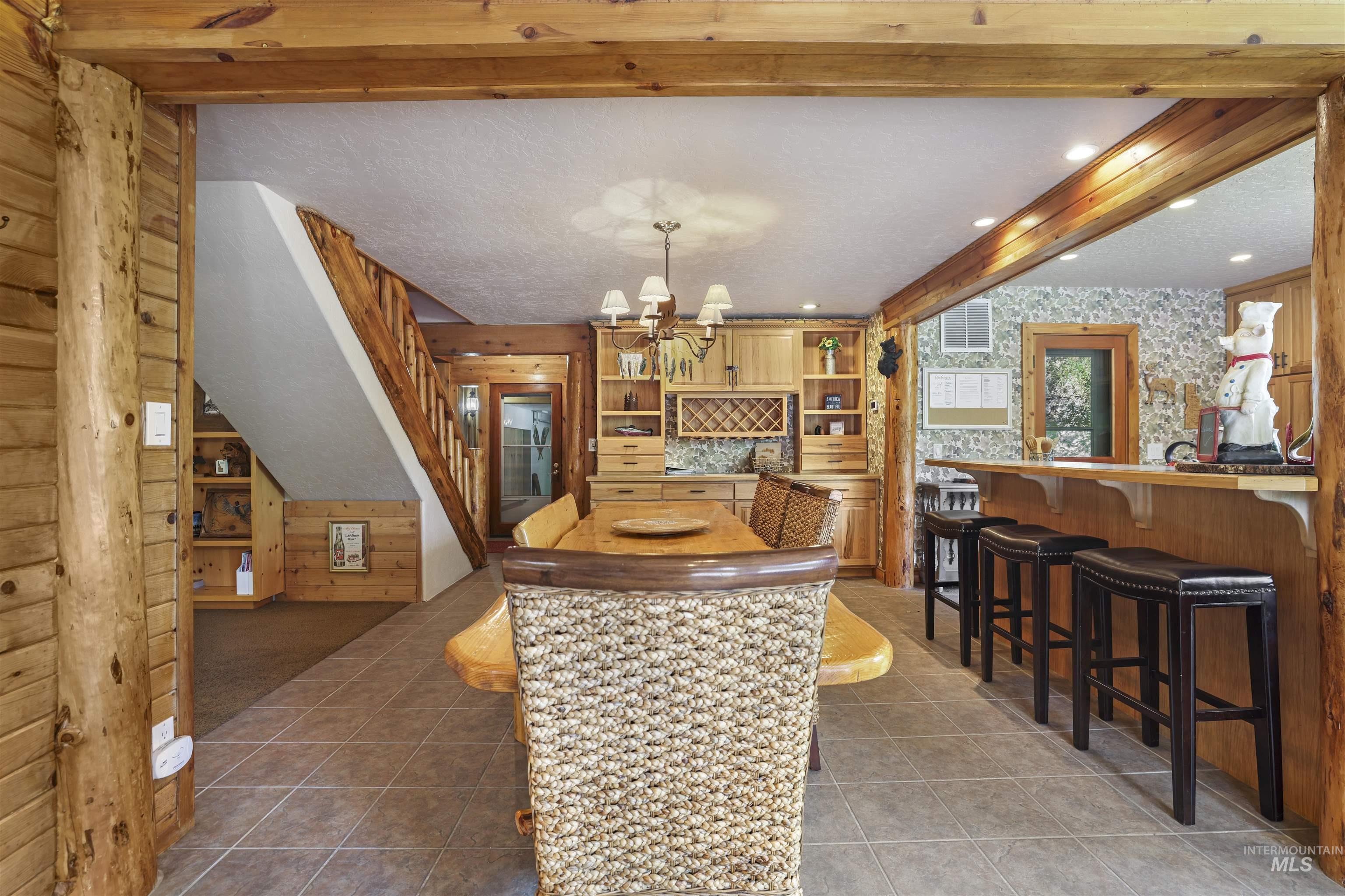 224 Dakota Road Mountain Home, ID 83647 - Photo 8 of 50 Open-concept dining area featuring tile flooring, a wood-finish dining table, and built-in cabinetry with a wine rack