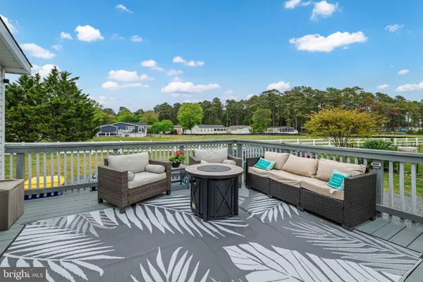 a view of a patio with couches chairs and wooden floor