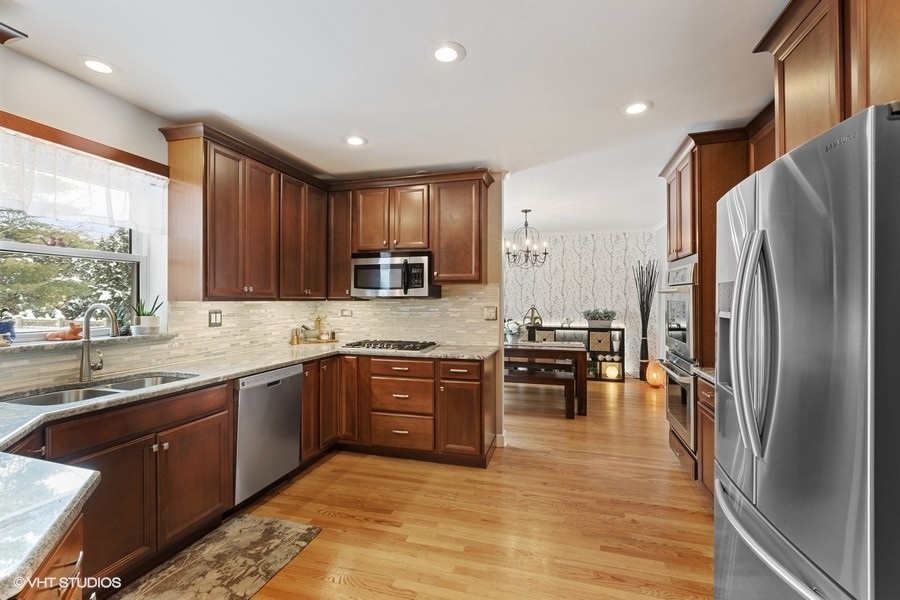 442 Kent Road Riverside, IL 60546 - Photo 17 of 45 a large kitchen with stainless steel appliances granite countertop a refrigerator a sink dishwasher a stove and a microwave oven with wooden floor