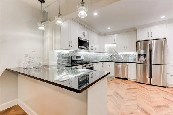 a kitchen with stainless steel appliances granite countertop a sink refrigerator and cabinets