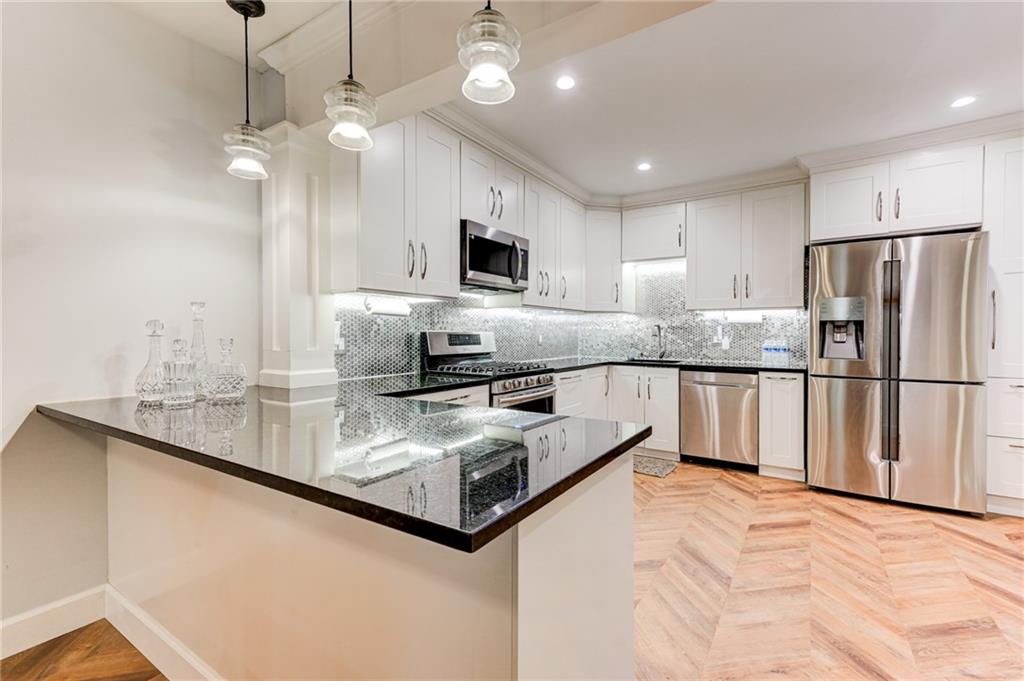 a kitchen with stainless steel appliances granite countertop a sink refrigerator and cabinets
