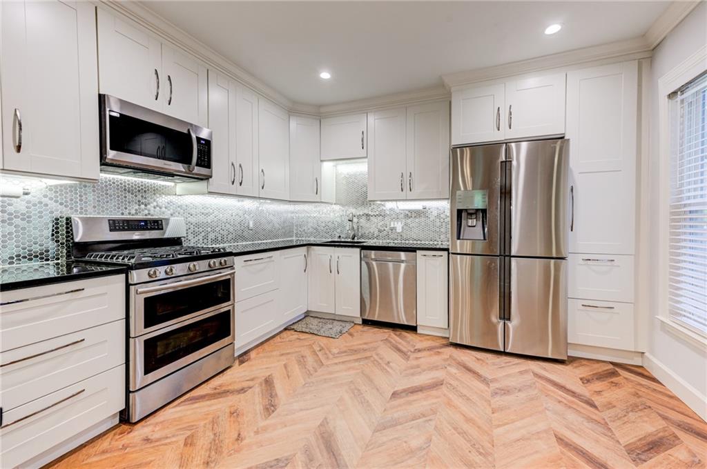 2075 Clairmeade Valley Road Northeast Atlanta, GA 30329 - Photo 29 of 51 a kitchen with granite countertop white cabinets and stainless steel appliances