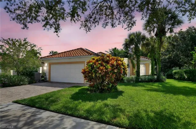 a view of a house with a yard and a tree