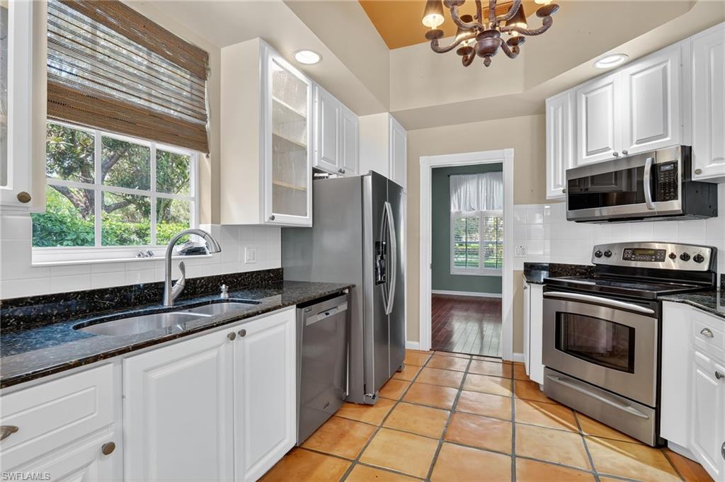 5902 Bermuda Lane Naples, FL 34119 - Photo 13 of 50 a kitchen with granite countertop a sink stainless steel appliances a window and a counter top space