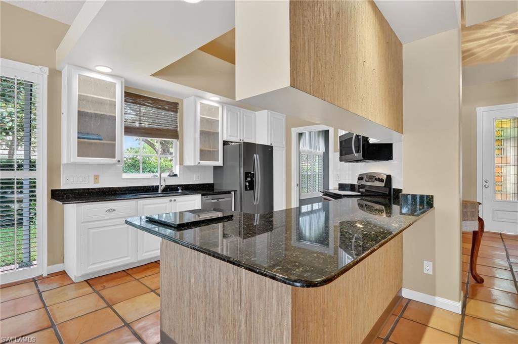 5902 Bermuda Lane Naples, FL 34119 - Photo 14 of 50 a kitchen with stainless steel appliances granite countertop a sink a stove and a refrigerator