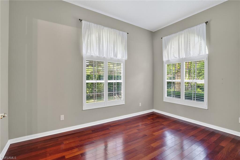 5902 Bermuda Lane Naples, FL 34119 - Photo 21 of 50 a view of an empty room with wooden floor and a window