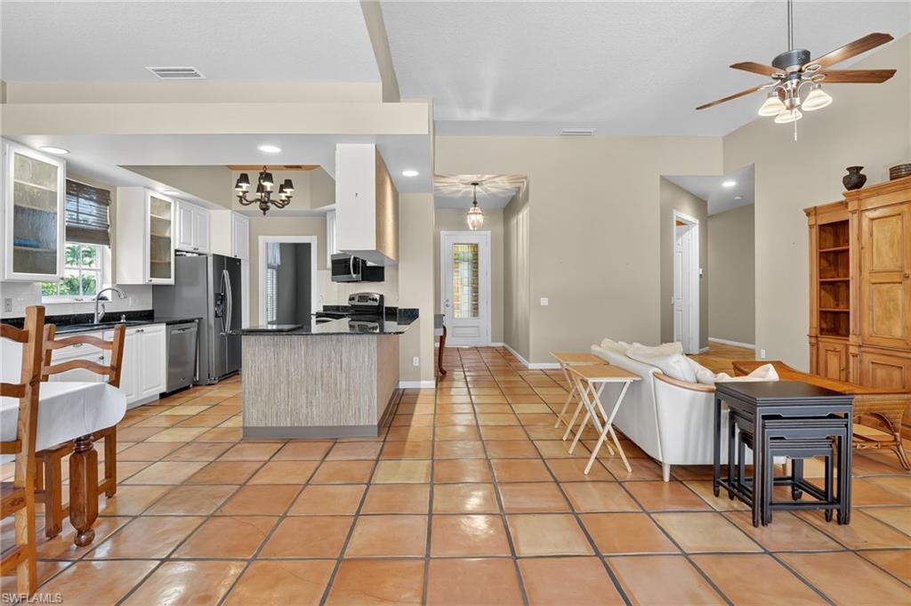 5902 Bermuda Lane Naples, FL 34119 - Photo 9 of 50 a living room with couches a dining table and chairs with wooden floor