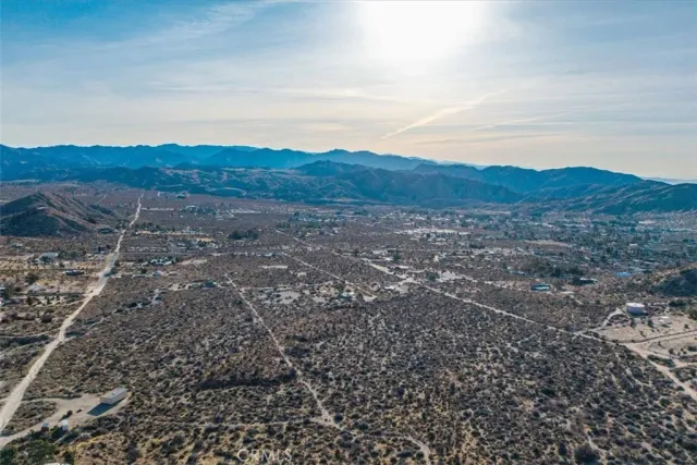 a view of a dry yard with mountains in the background