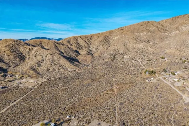 a view of a dry yard with mountains in the background