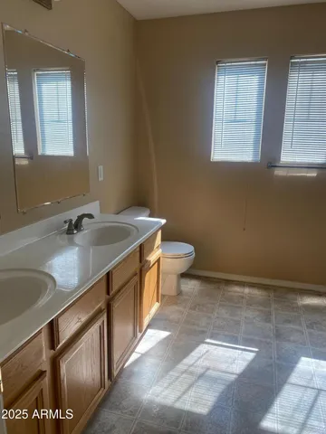 a bathroom with a sink a toilet and a mirror