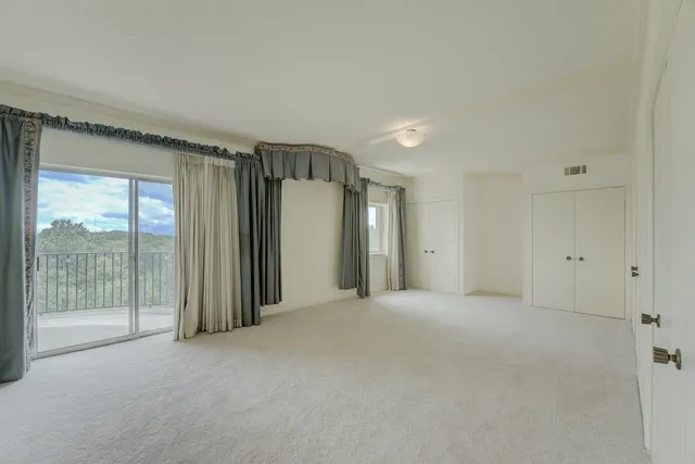 a view of a big room with windows and closet area