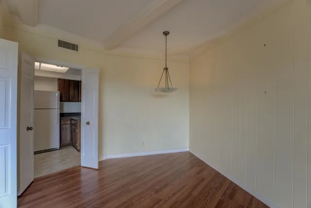 a utility room with refrigerator and cabinets