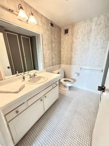 a bathroom with a sink toilet and a mirror