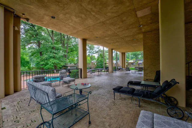 a living room with patio furniture and a floor to ceiling window