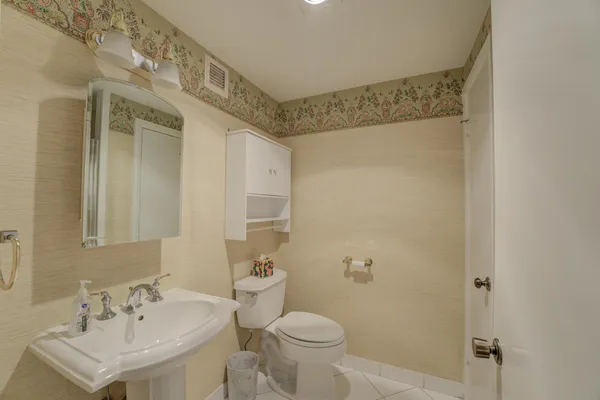 a bathroom with a sink toilet and a mirror