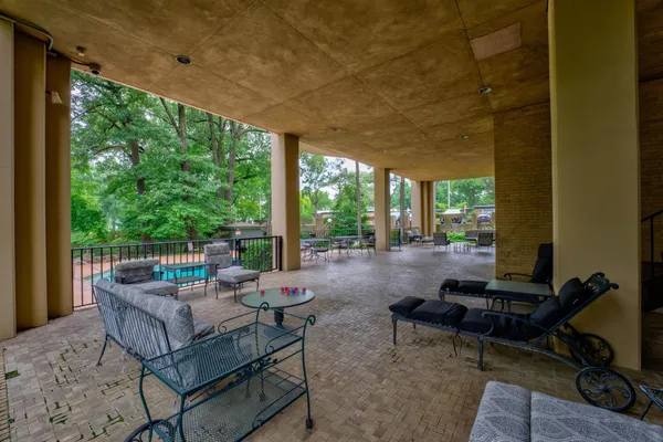 a living room with patio furniture and a floor to ceiling window