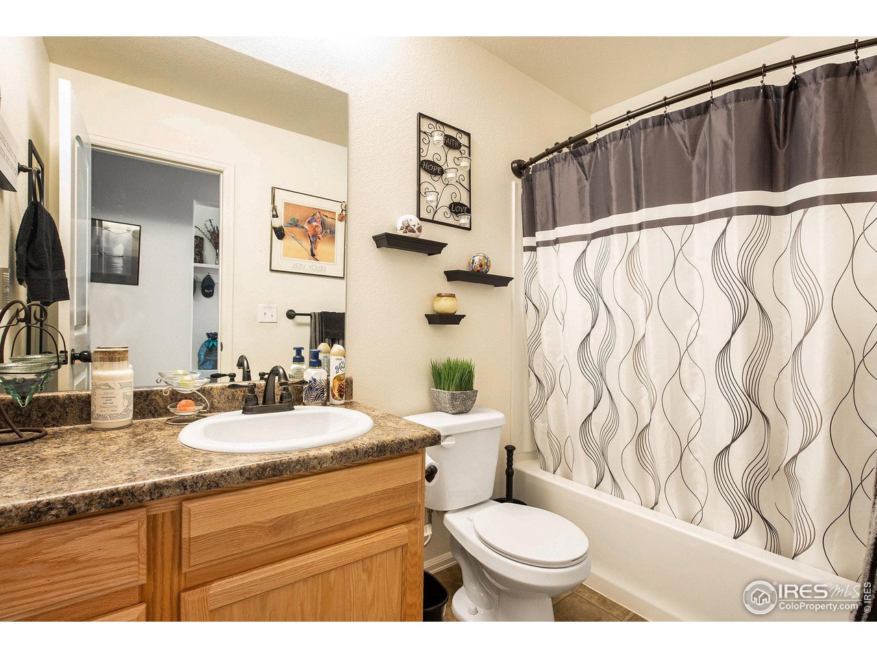 1329 85th Avenue Greeley, CO 80634 - Photo 17 of 22 a bathroom with a granite countertop sink toilet and shower