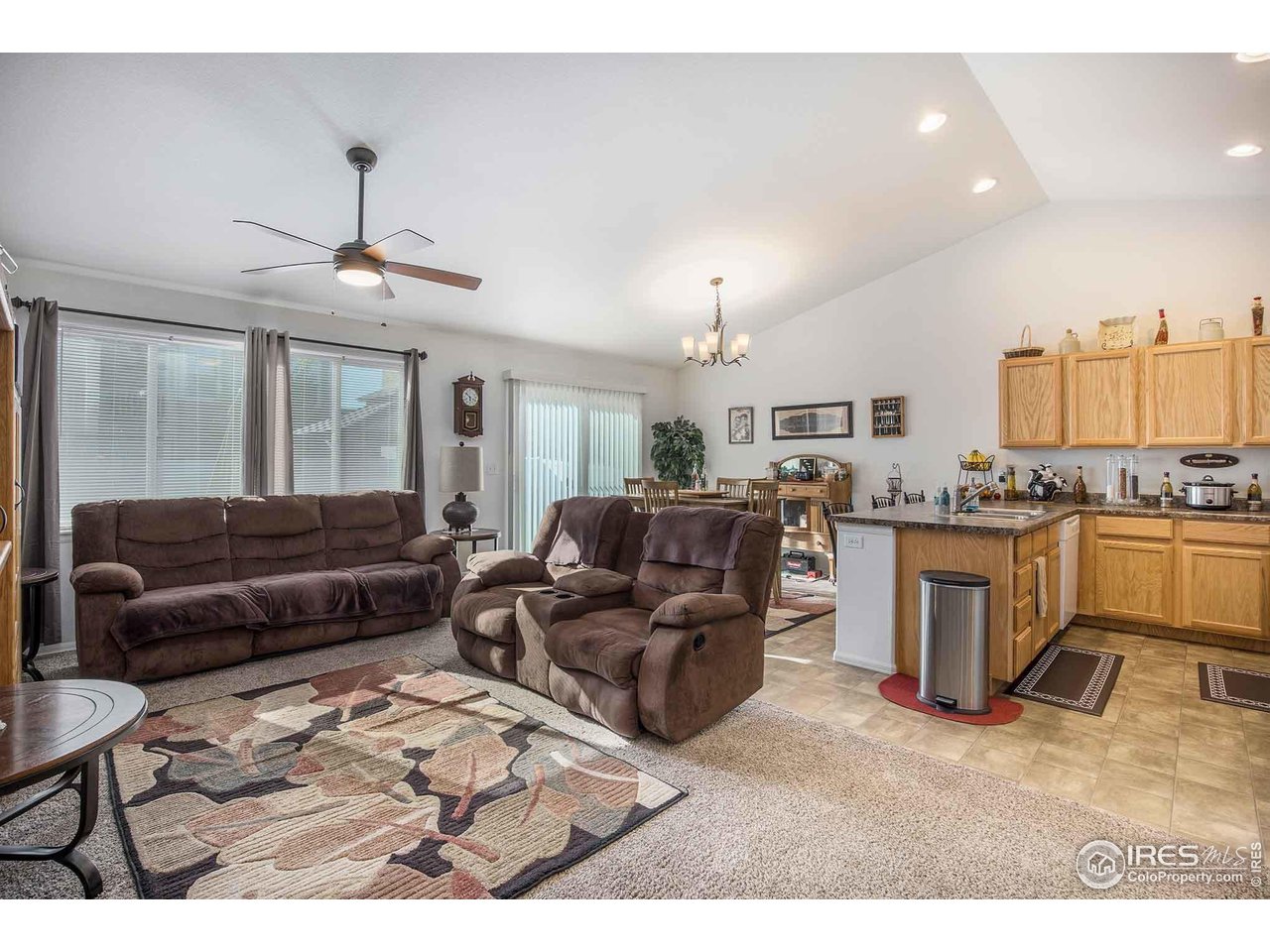 1329 85th Avenue Greeley, CO 80634 - Photo 7 of 22 a living room with furniture kitchen view and a chandelier