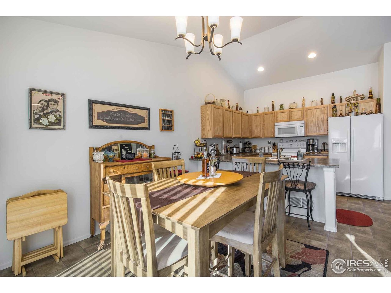 1329 85th Avenue Greeley, CO 80634 - Photo 8 of 22 a dining hall with stainless steel appliances kitchen island granite countertop furniture and a view of kitchen